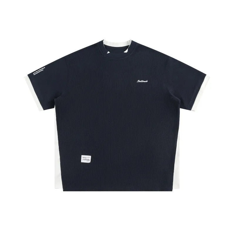 Loose-fit short-sleeved T-shirt with embroidered retro alphabet design on waffle-textured fabric.