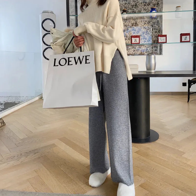Women's cream white high waist wide-leg knitted trousers with a long mopping hem and elastic waistband.