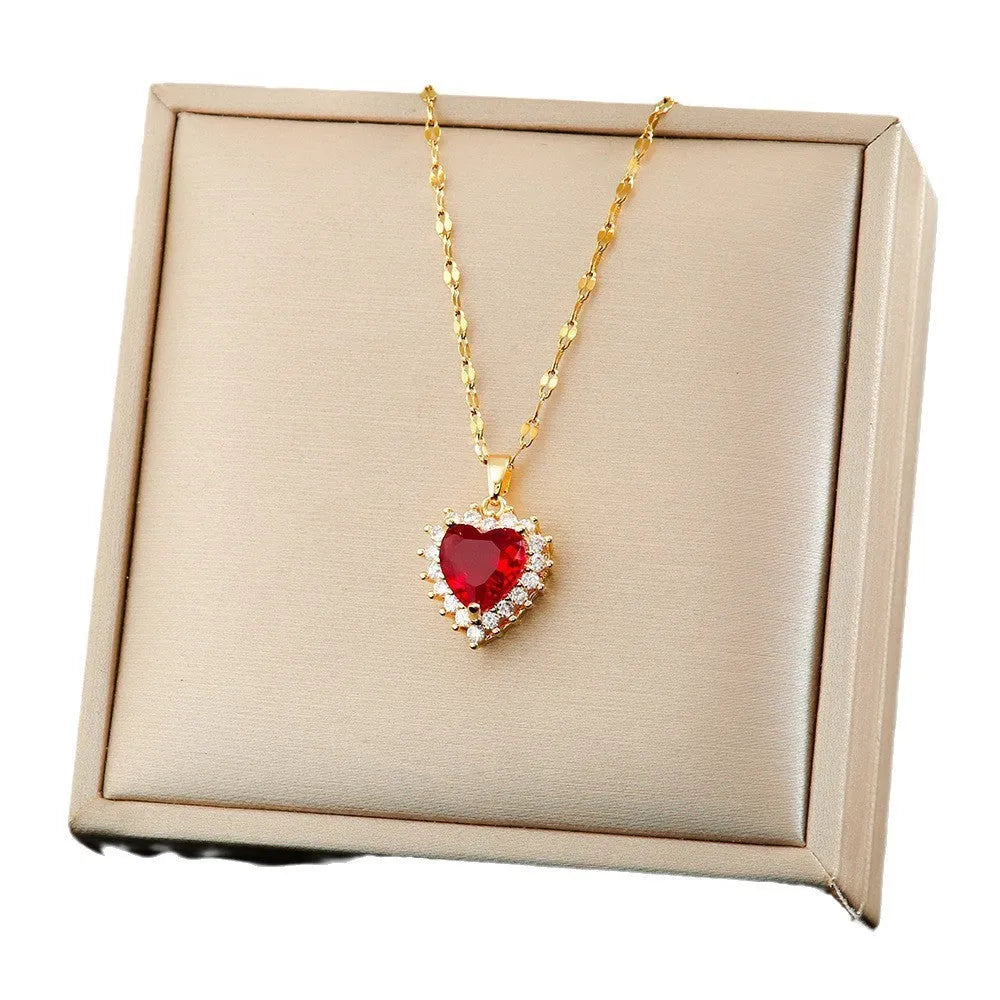 Women's heart-shaped jewellery set with matching necklace, stud earrings, and ring in electroplated gold red finish