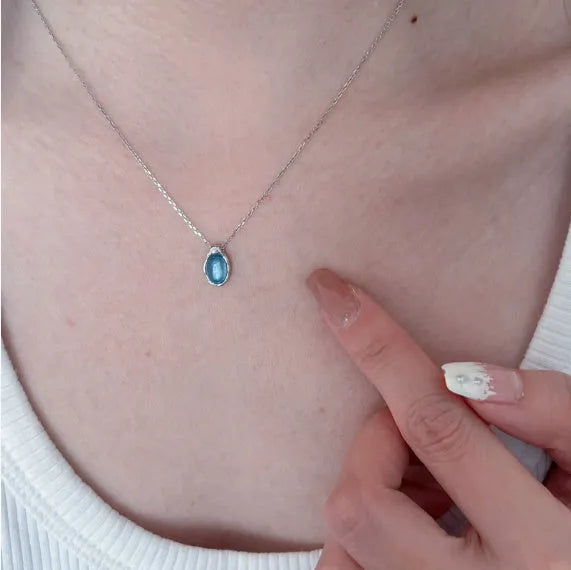 Navy blue geometric water drop pendant necklace on model showing adjustable cross chain design