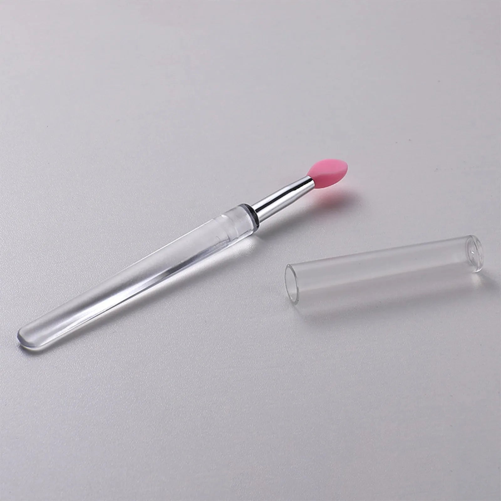 A reusable silicone lip brush with a handle and protective cap, shown in one of eight available colours.