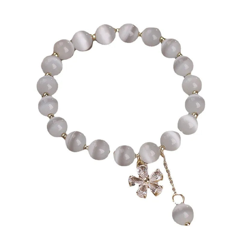 Women's white cat's eye stone bracelet with flower tassel and safety buckle pendant.