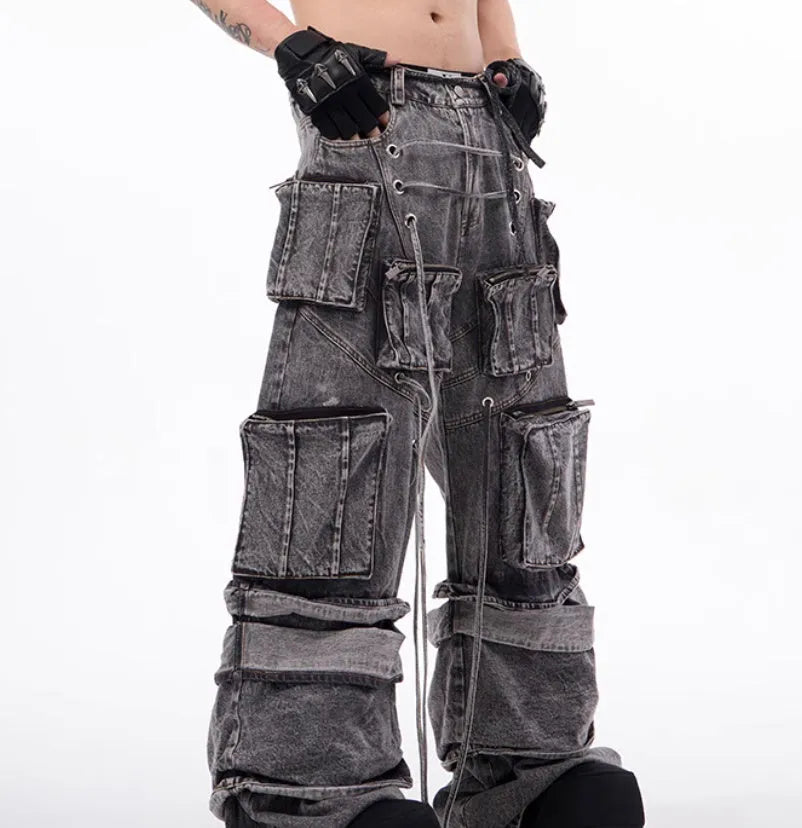 Grey distressed denim overalls with rope stitching detail on a hanger.