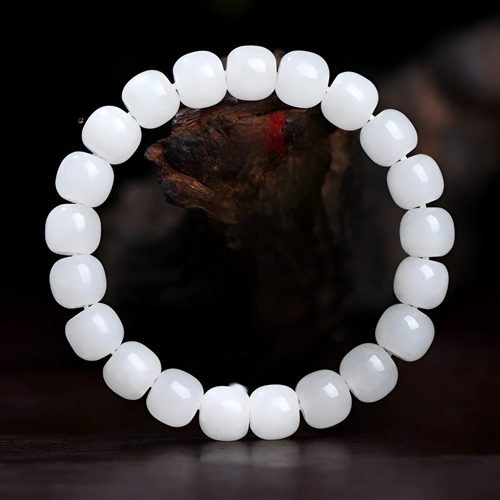 White Hetian jade barrel bead bracelet for men and women on a plain background.