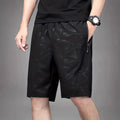 Man wearing loose grey printed sports shorts on a beach
