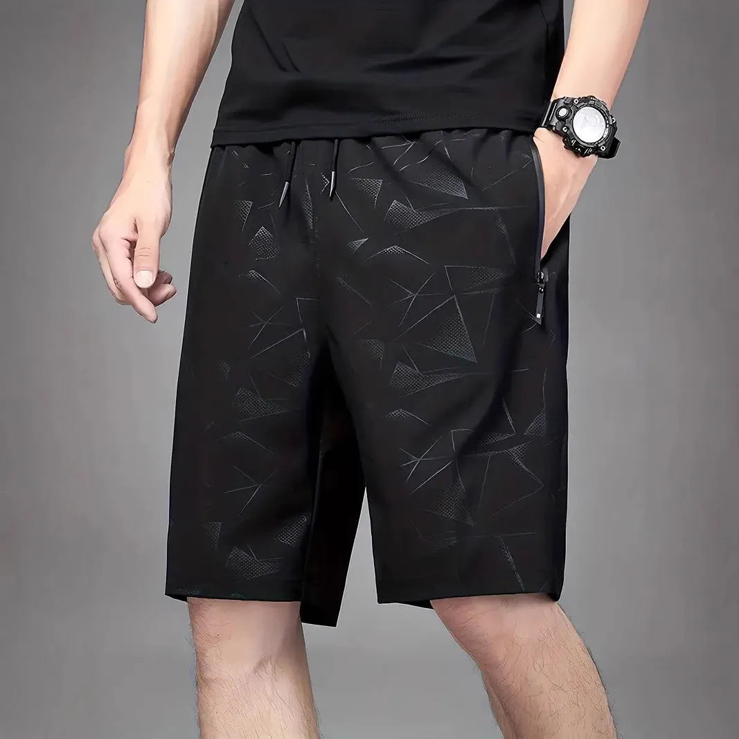 Man wearing loose grey printed sports shorts on a beach