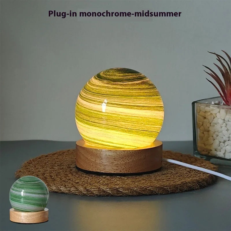 Modern planet-shaped USB night light with dimmable three-colour LED on its base.