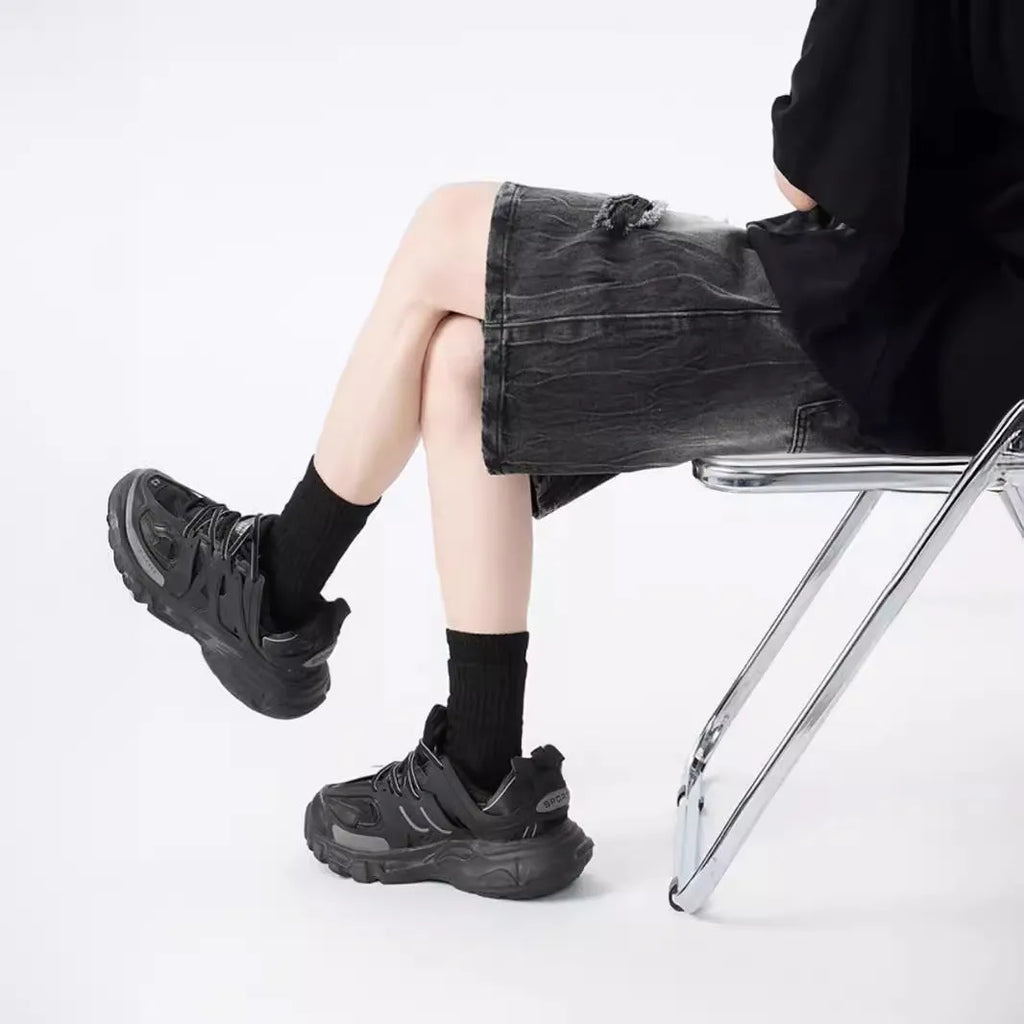 Loose washed blue denim shorts with a ripped knee detail on a mannequin, showing the retro fit.
