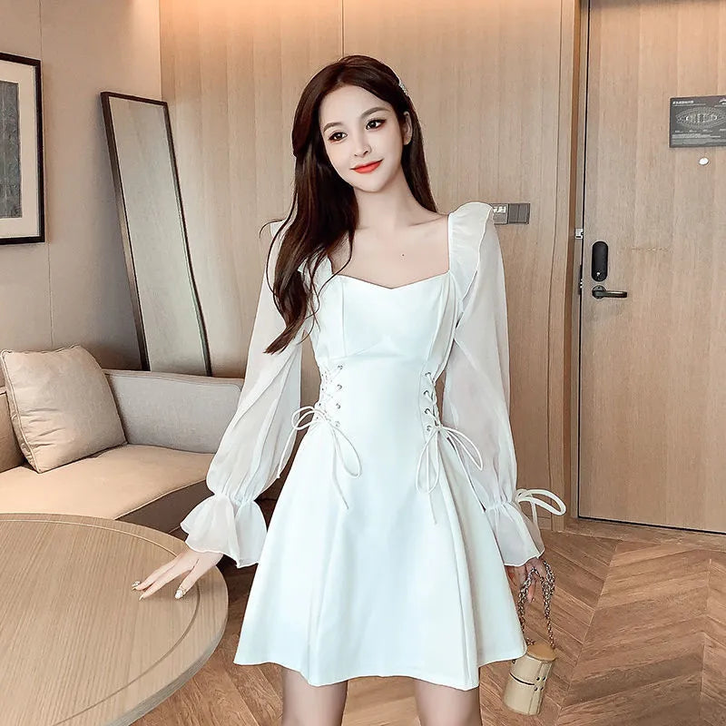 White women's long sleeve maxi dress with patchwork detail and a fitted waist.
