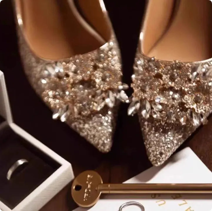 Champagne coloured bridal shoes with pointed toe, fine heel, and rhinestone floral decoration.