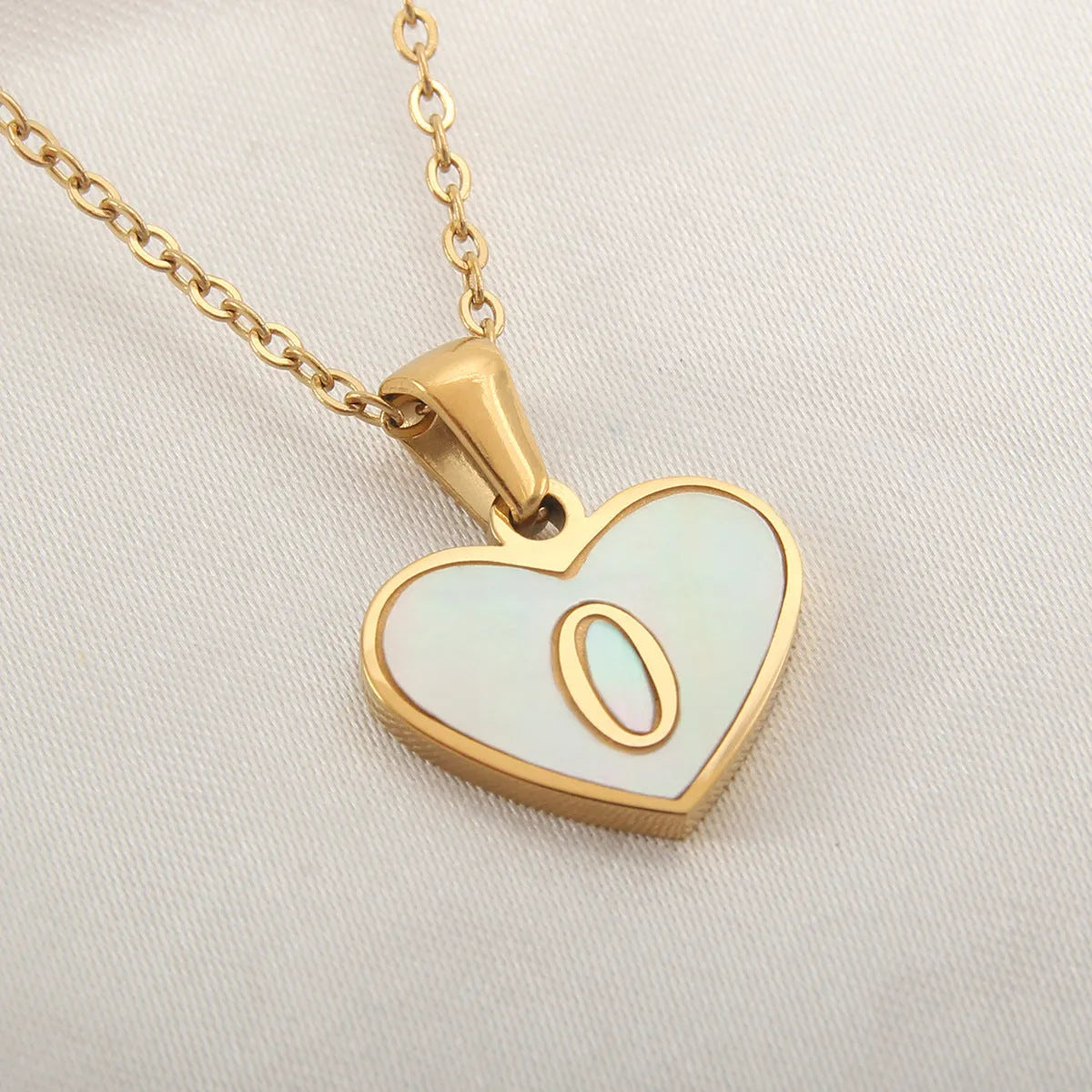 Gold plated heart-shaped necklace with white shell pendant on adjustable stainless steel chain