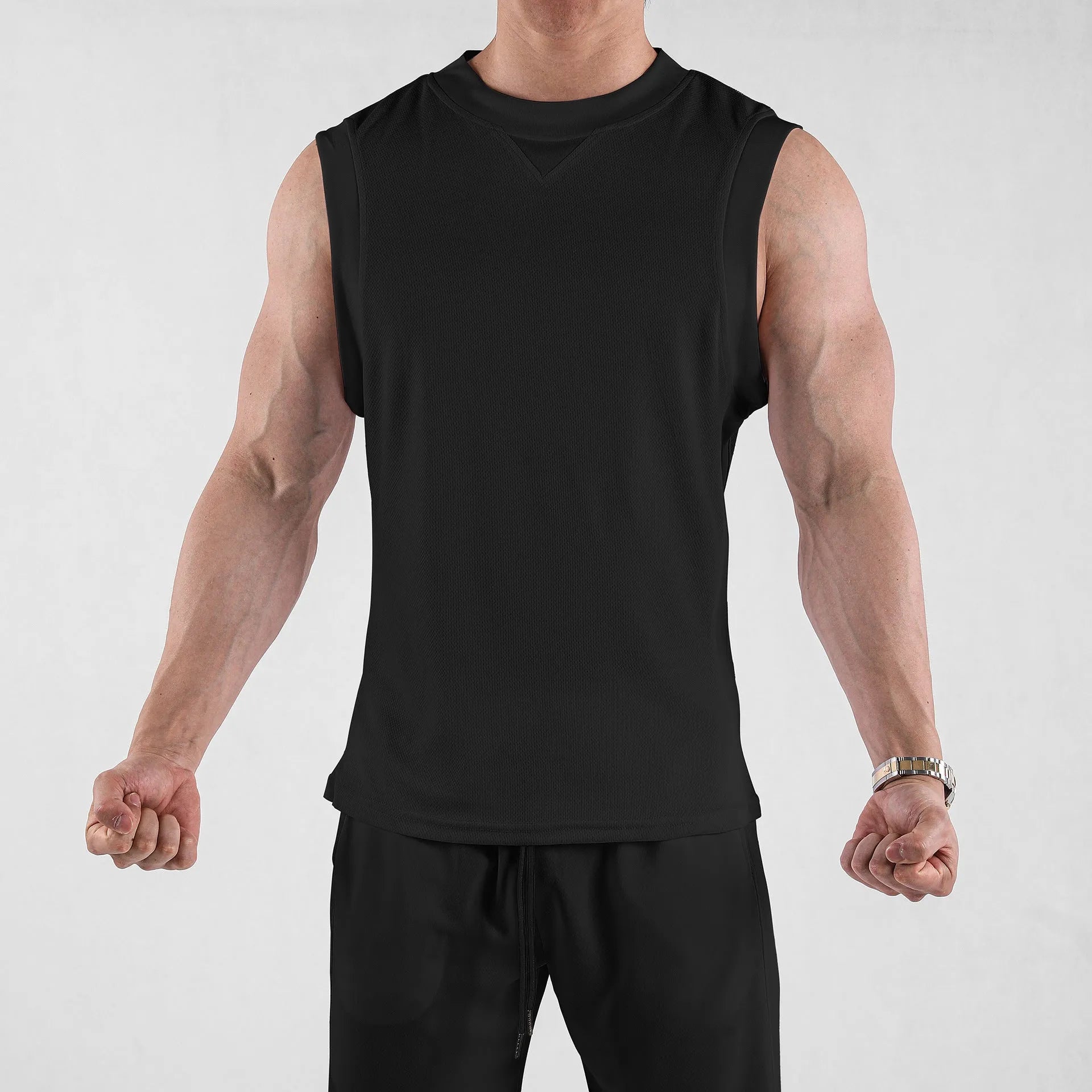 Man wearing a loose fit black quick-dry sports vest for summer fitness activities.
