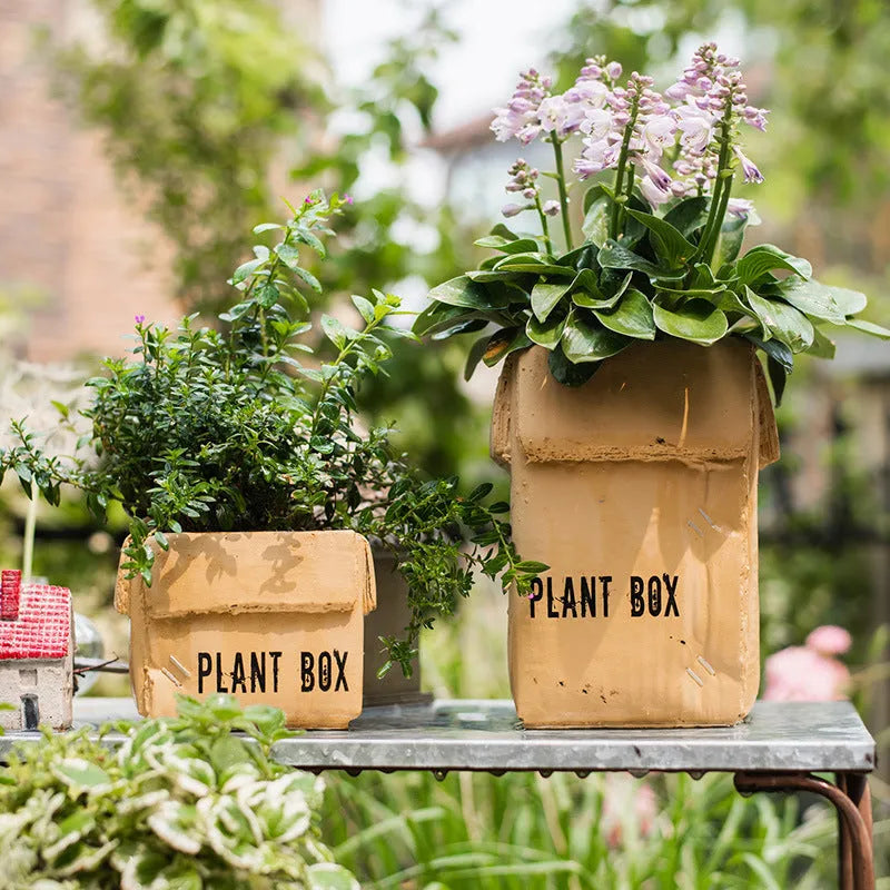 Cement flowerpot styled as a brown paper box with drainage hole for indoor balcony gardening