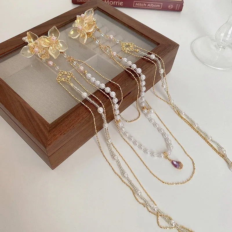 Women's hairpin with pearl, diamond and flower design featuring long tassel detail and gold-coloured grip
