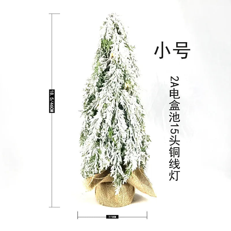 Small 24-inch white artificial Christmas tree with LED lights and snow spray on plastic branches
