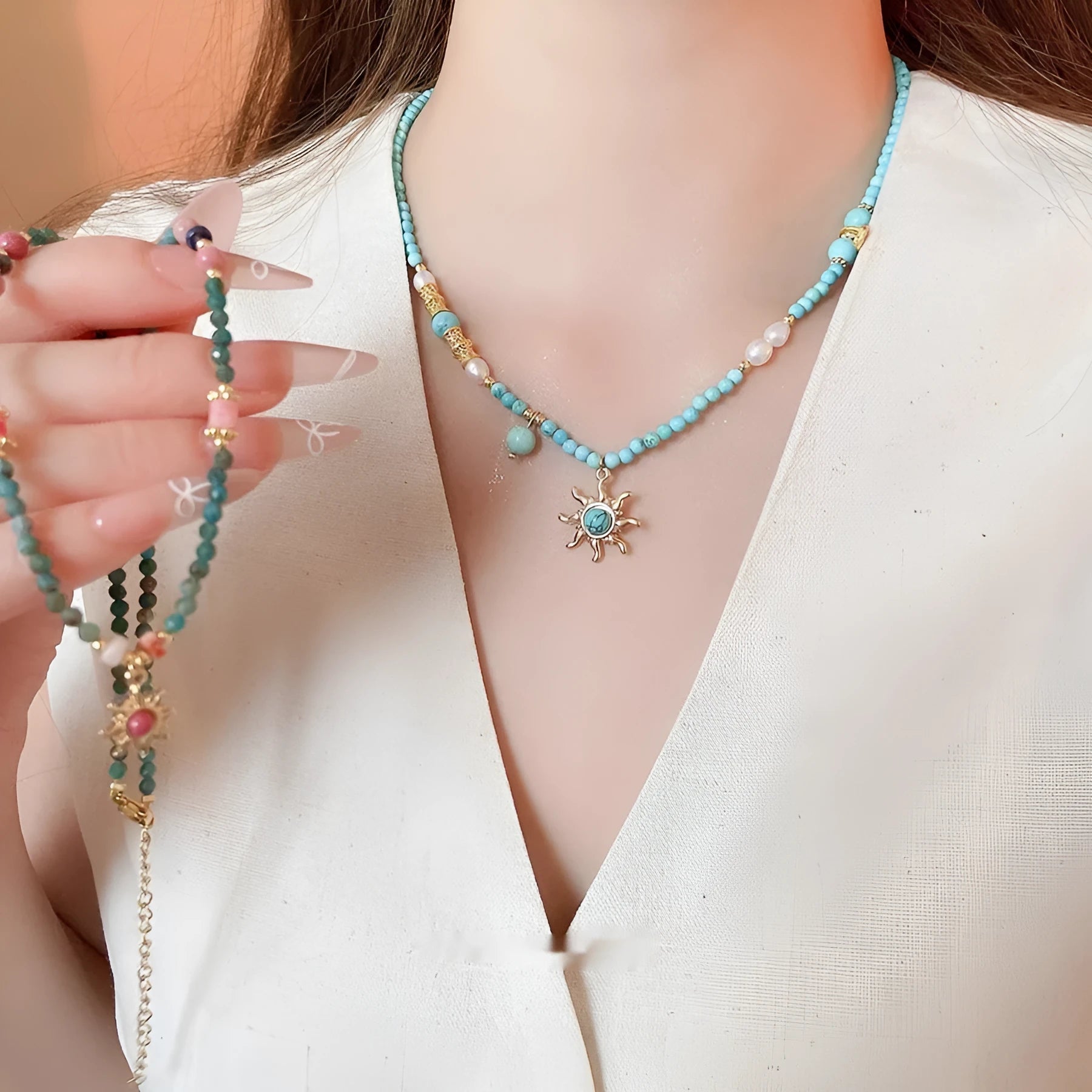 French royal style sun necklace with freshwater pearls and a blue stone geometry pendant on a gold chain.