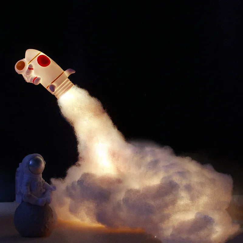 DIY astronaut rocket night light kit with LED string lights, small model, and straws for assembly on a desk.