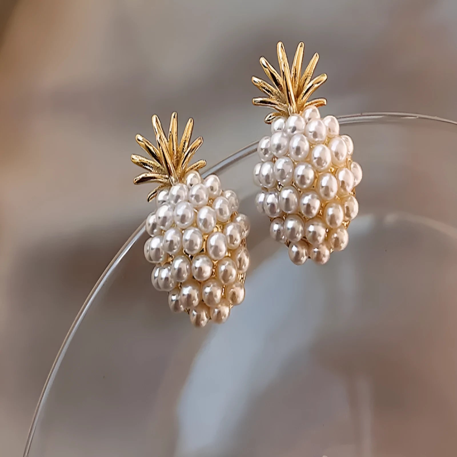Korean style gold pineapple starfish pearl earrings made from electroplated alloy with inlaid stones.
