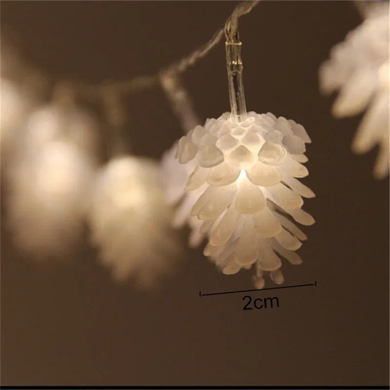 Warm white LED pine cone light string with plastic shells, powered by two AA batteries.