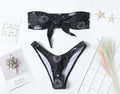 Black one-piece swimsuit with bikini print and a backless split tube top design.