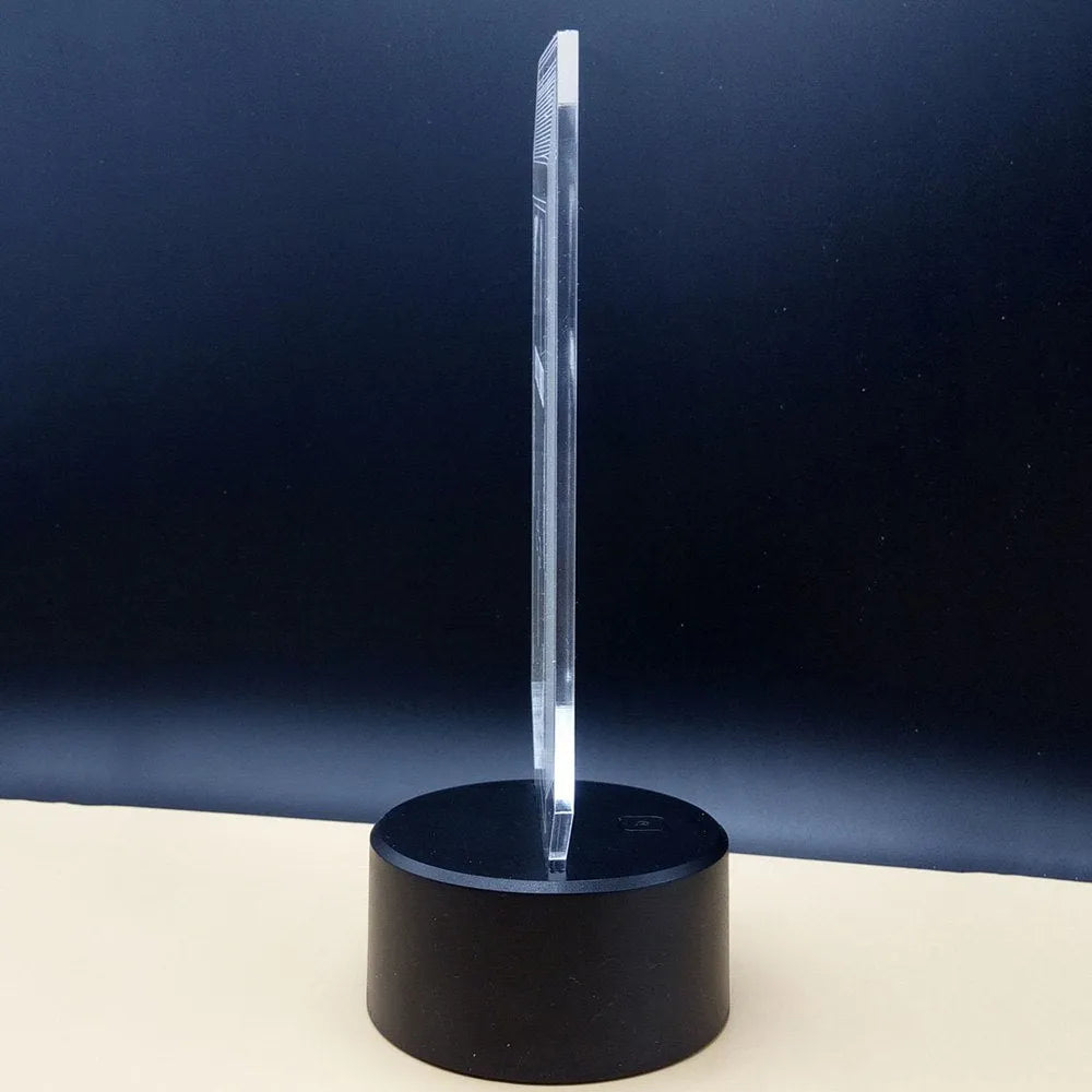 3D acrylic illusion LED desk lamp with remote control on a wooden surface, showing colour gradient effect.