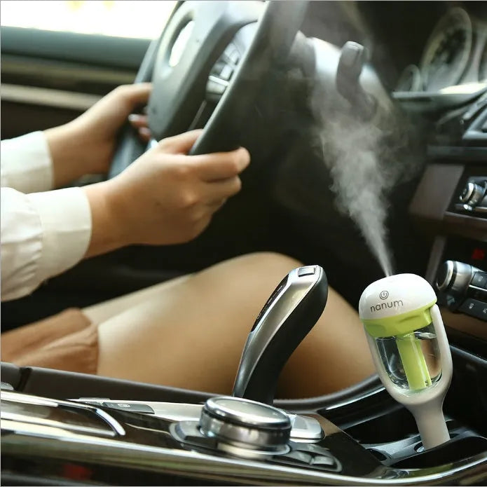 Compact blue car humidifier air purifier with essential oil diffuser function on car dashboard