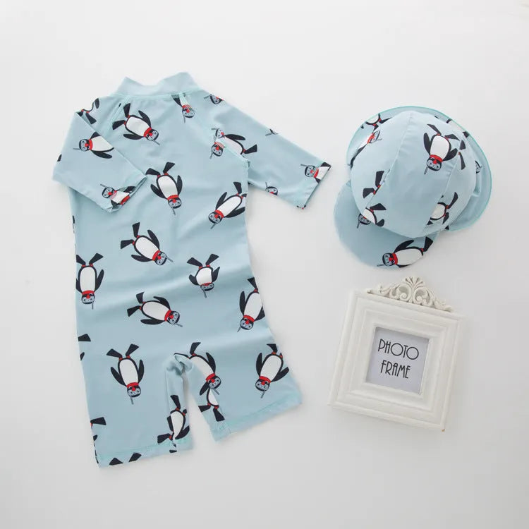 Blue boys two-piece penguin swimsuit with long sleeves and a matching swim cap.