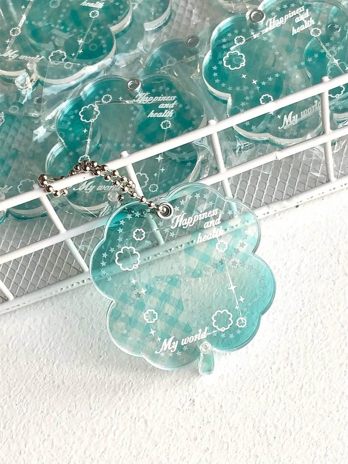 Acrylic four-leaf clover pendant charm for phone or keychain in blue or green colours.