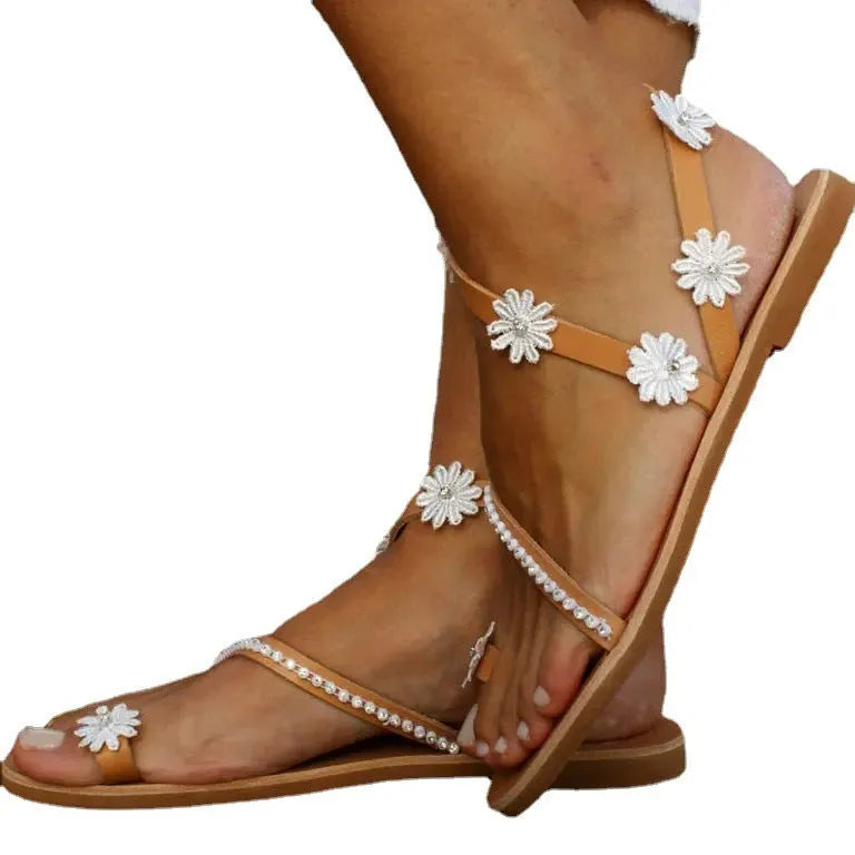 Brown women's flat Roman sandals with a herringbone toe design and ethnic floral pattern on the straps.