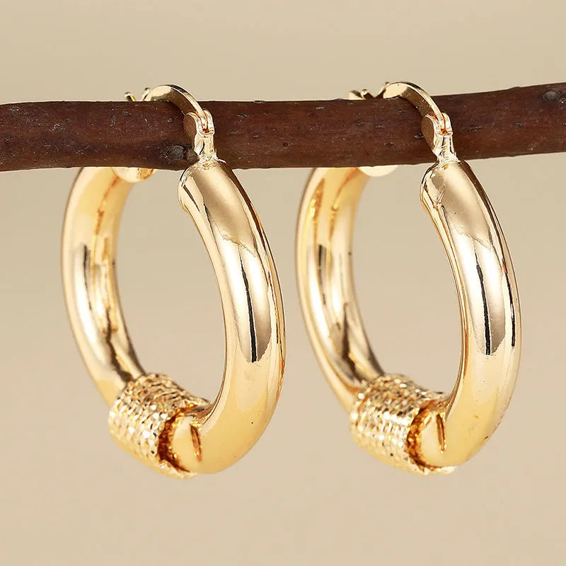 Geometric copper earrings with ring and line design in a gold colour.