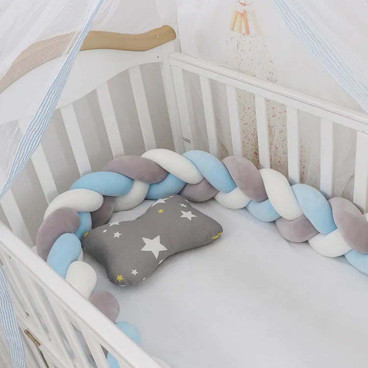 Bendable braid-knot baby crib bumper in spandex velvet, shown in a light grey colour wrapped around a cot.