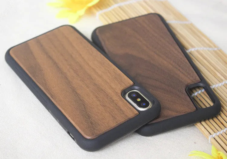 Wooden iPhone case with carbonized bamboo back and black TPU bumper frame on a table.