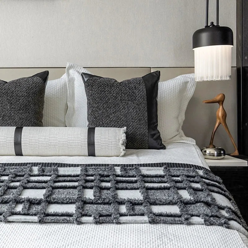 Grey and white plaid polyester bed runner blanket set with matching pillowcase and round leather-look cushion on a bed