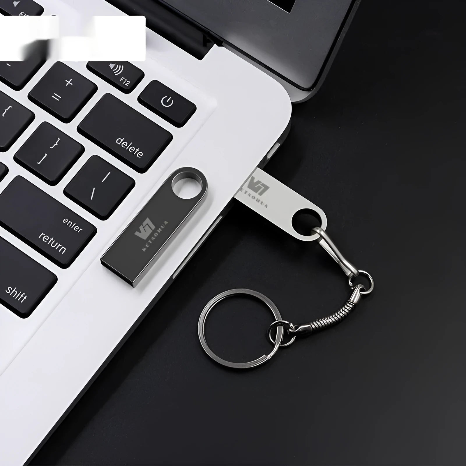 Silver metal car-shaped USB flash drive on a white background, showing USB connector.