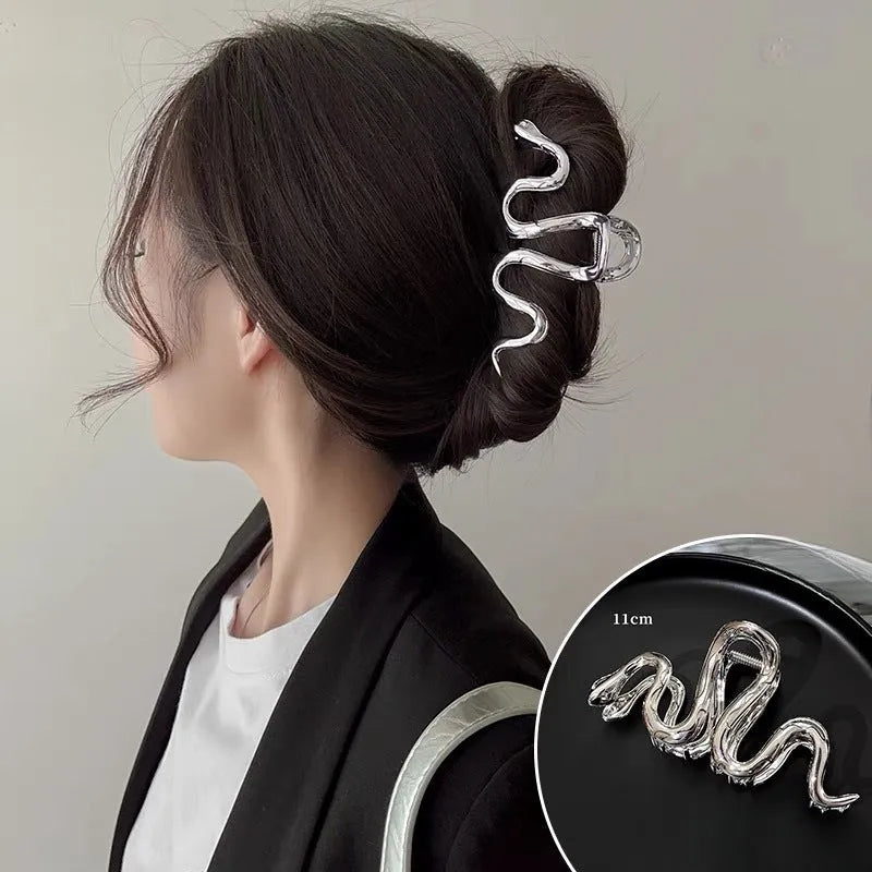 Silver metal Slytherin serpentine hair clip barrette measuring 10.5cm on a dark background