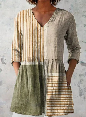 A woman wearing a printed, loose-fitting dress with a wide waist and three-quarter length sleeves.