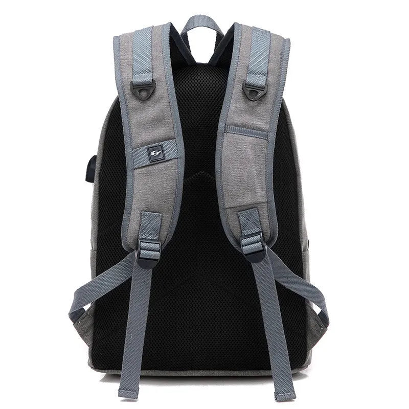 Canvas backpack with USB charging port showing computer compartment and zipper pocket