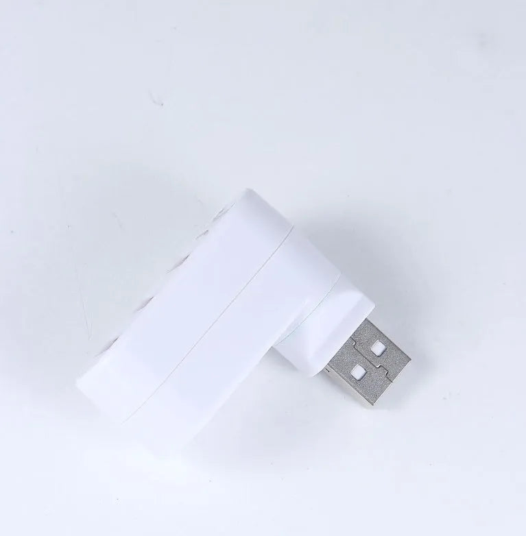 Black and white 4-port USB 2.0 splitter hub shown next to a laptop