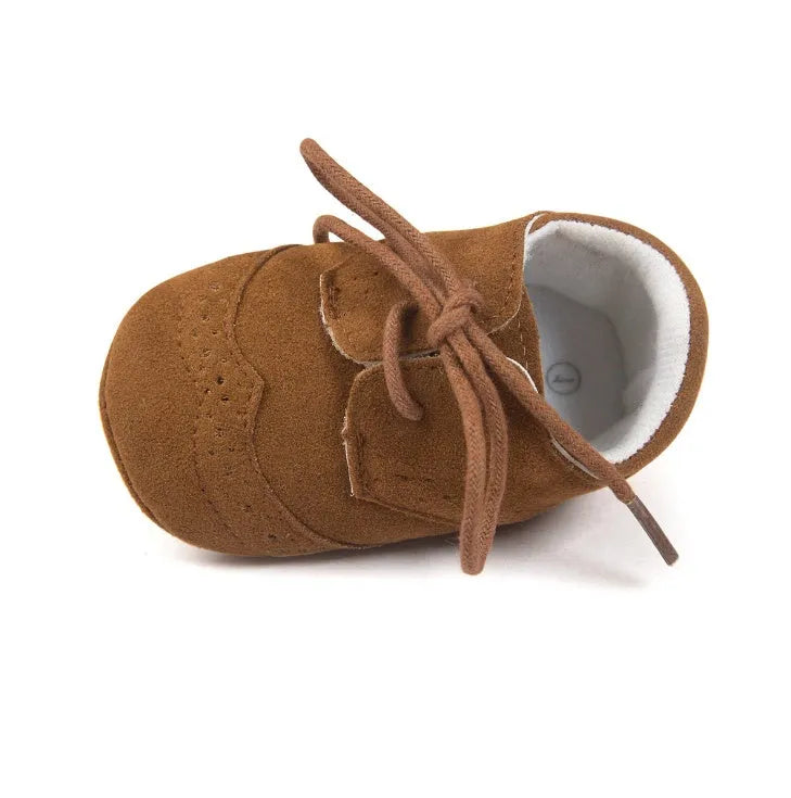 Vintage baby shoes with soft soles in light brown colour showing synthetic leather upper