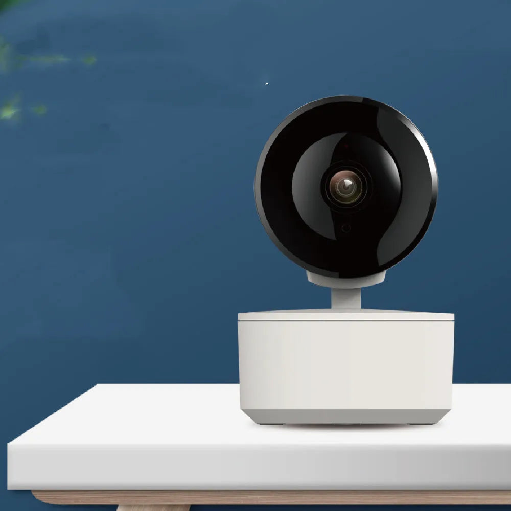 White indoor Wi‑Fi security camera with lens, shown on a desktop with power adapter