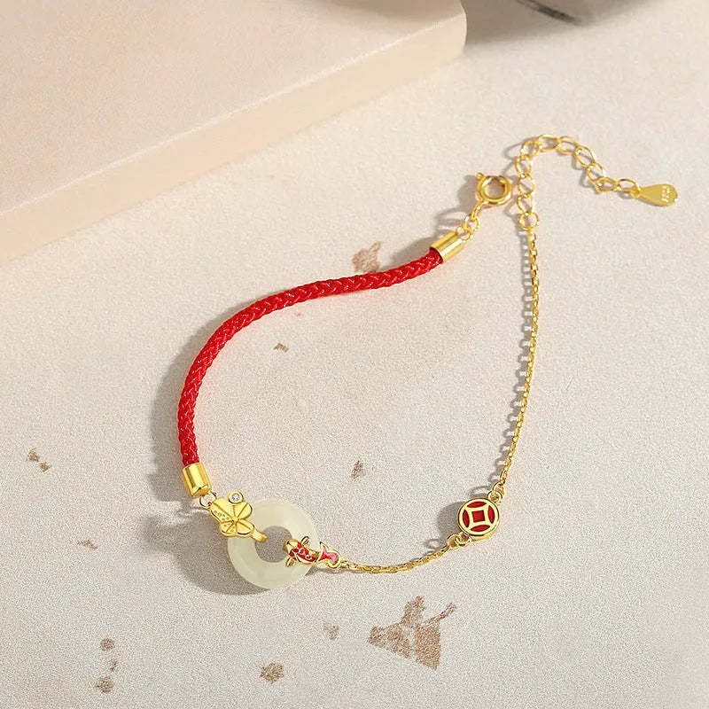 Women's red rope bracelet with silver and gold peace buckle charm featuring koi fish design