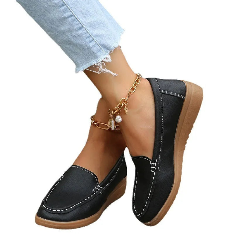 Women's PU leather slip-on loafers in round toe flat heel design showing car suture detailing