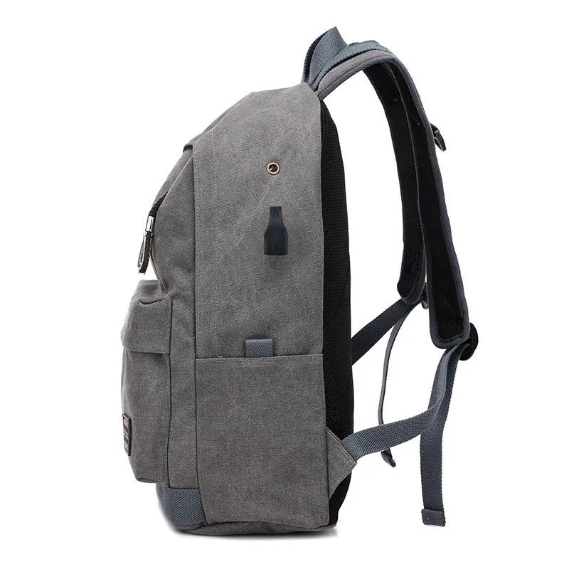 Canvas backpack with USB charging port showing computer compartment and zipper pocket
