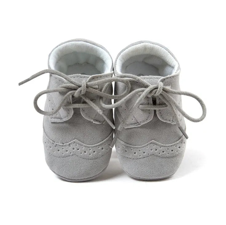 Vintage baby shoes with soft soles in light brown colour showing synthetic leather upper
