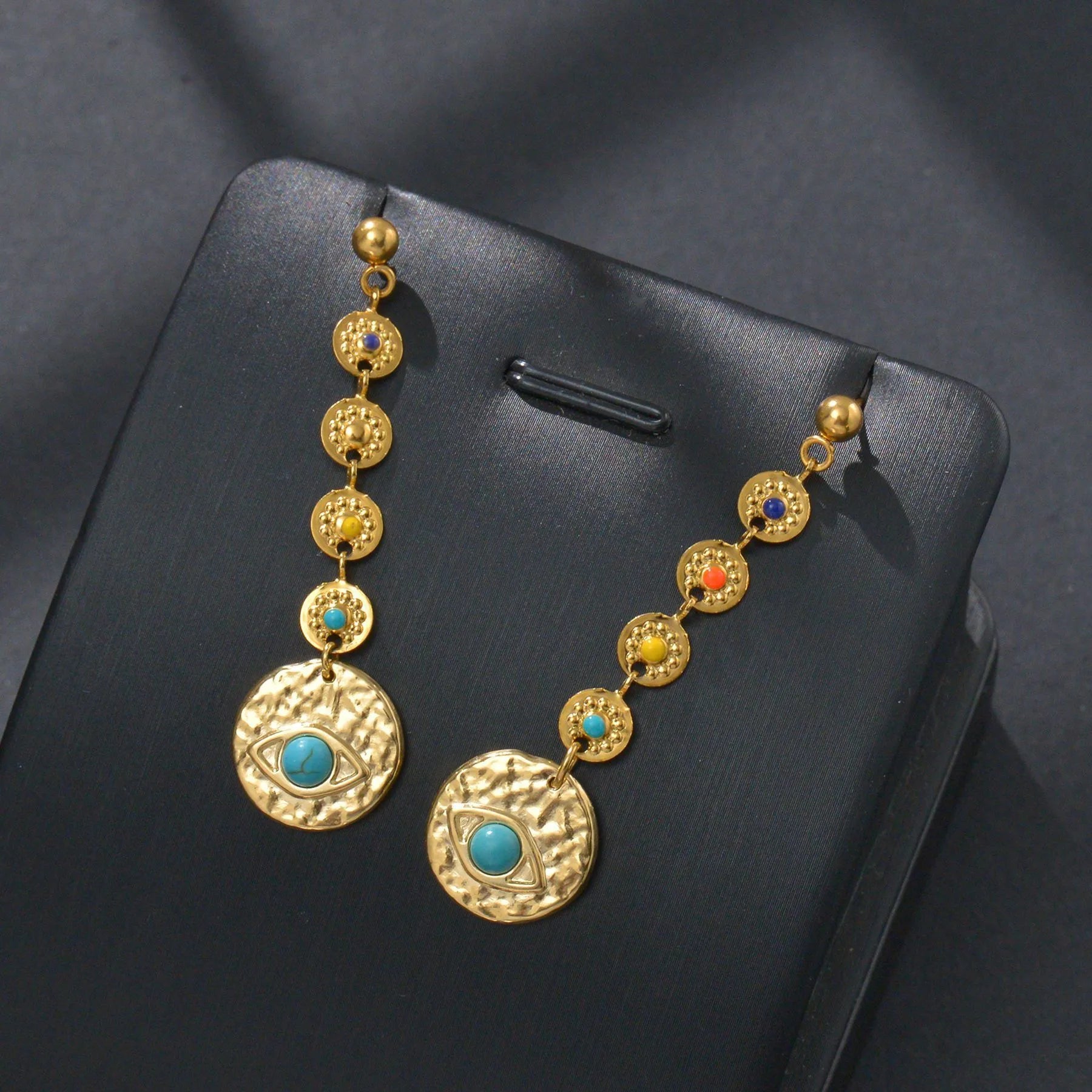 Geometric stainless steel statement earrings showing star, eye, and sun design options.