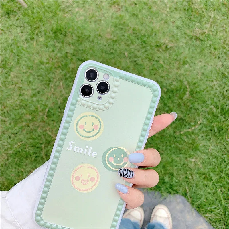Green TPU iPhone case with smiley face pattern and polka dot frame geometric design