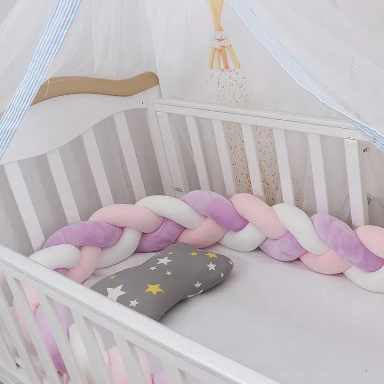 Bendable braid-knot baby crib bumper in spandex velvet, shown in a light grey colour wrapped around a cot.