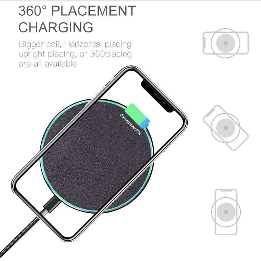 Black Qi wireless charging pad with built-in stand for iPhone 11 on a desk.