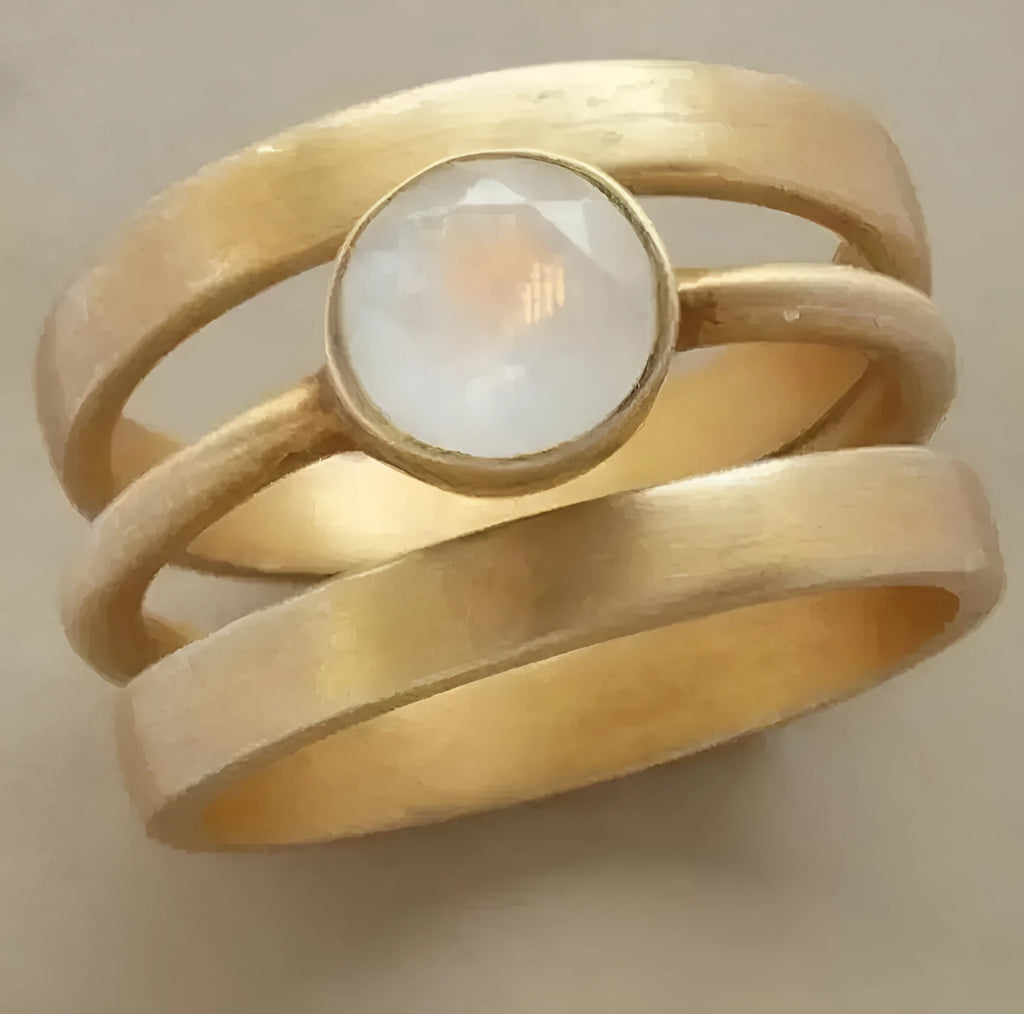 Geometric hollow gold-plated ring with micro-inlaid white chalcedony stones on a titanium steel band.