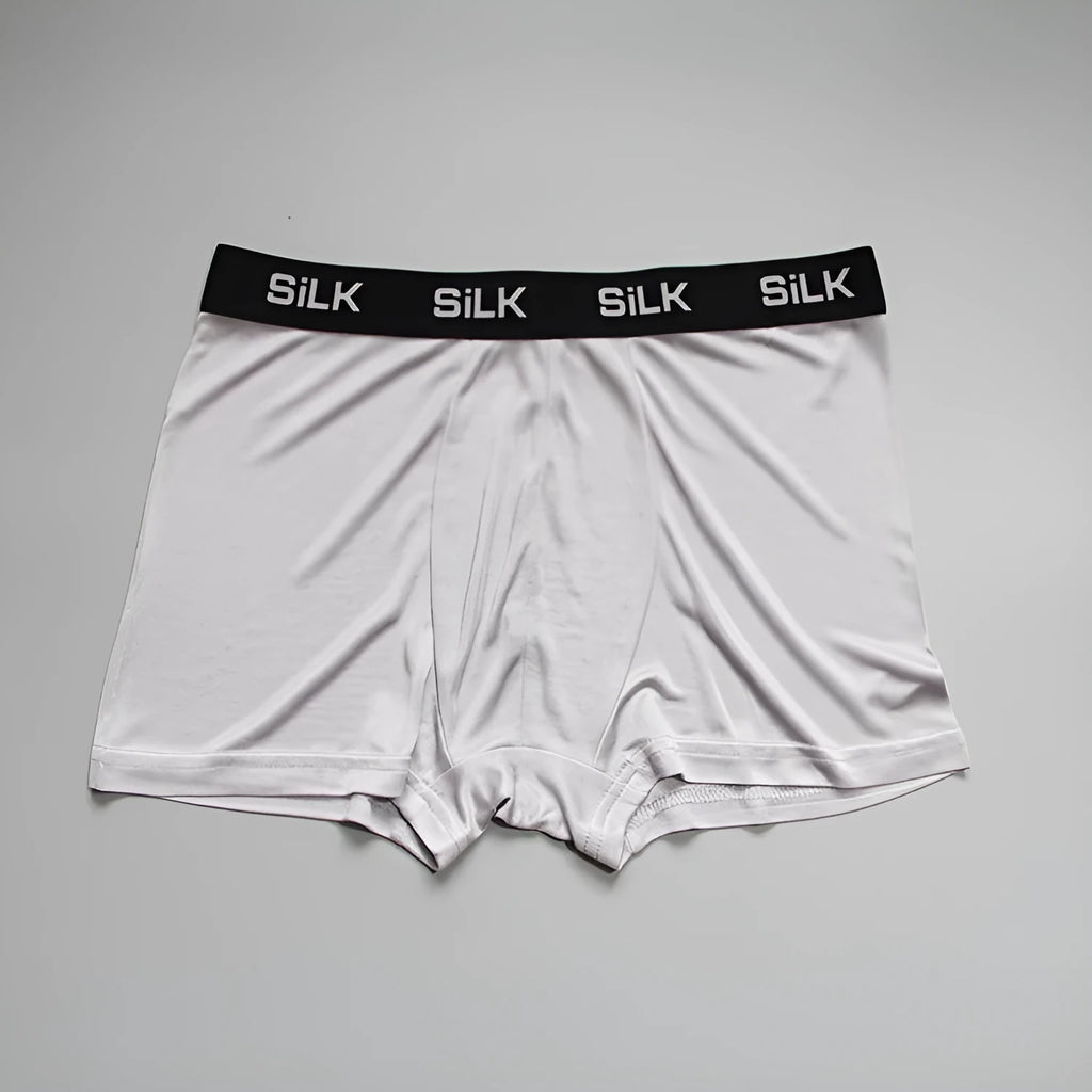 Man wearing loose fit navy blue silk shorts with a mid waist design.